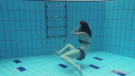 Redheaded Katrin stripping underwater