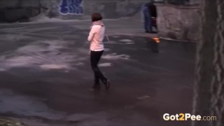 Frau pisst im Winter in einer Stadt