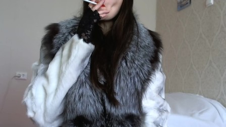 Smokes sexually naked in stockings and in a fur coat