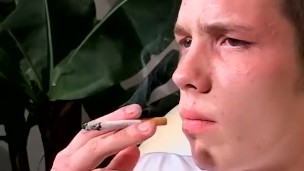 Young gay Denis lights up cigar and tugs cock with hand