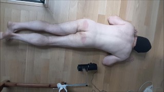 Moaning guy gets a tough spanking from machine with wooden canes