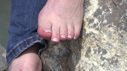 the feet of a mature lady on stones
