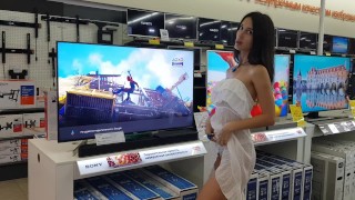 The girl chooses a TV in the store and shows her pussy along the way