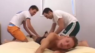 Restrained twink in shorts tickled by two foot fetish gays