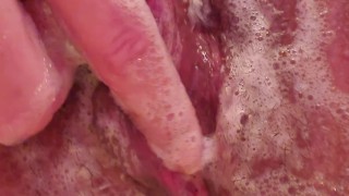 Soapy, wet pussy being played with in a bubble bath. 
