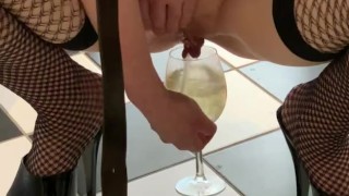Dirty slut in plaid skirt and stripper heels fills a  glass with piss