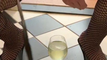 Dirty slut in plaid skirt and stripper heels fills a  glass with piss