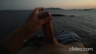 Skinny guy masturbates on a cliff during a sunset in Ibiza