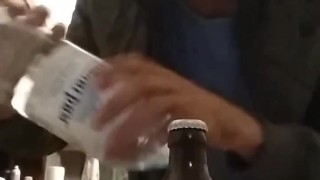 opening a bottle of beer with a bottle of mineral water