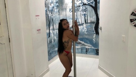 Prostituta colombiana bailando en el tubo para sus clientes