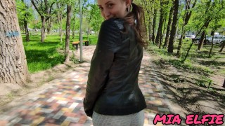 Schoolgirl with big eyes walks in the park after school in a leather jacket