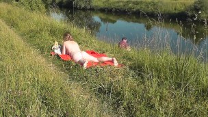 Riverside naked milf sunbathing is not shy about random fisher. Outdoors. Wild beach. Public nudity