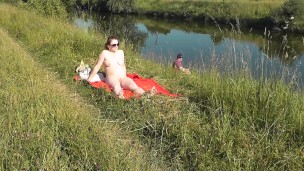 Riverside naked milf sunbathing is not shy about random fisher. Outdoors. Wild beach. Public nudity