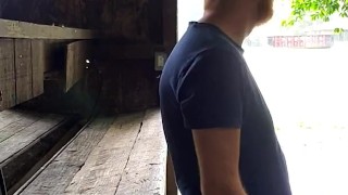 Red headed guy playing with dick outside in the rain while people drive by