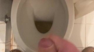 a guy pisses and then masturbates in the bathroom, cumming with his nice cock all over the place