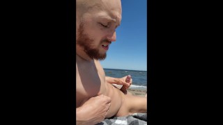 Brainwashed gooner boy strokes his cock on public beach