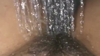 Girl pisses in a stream of water in the shower