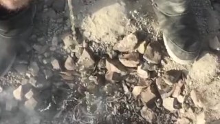Slow motion piss too put out the campfire in the desert