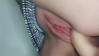 Ella se folla su dildo de pie bajo su vestido