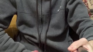 A guy in a gray sweater on a chair cums with a waterfall