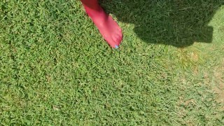 Walking around barefoot wearing red nylon stockings