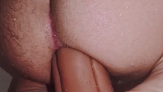 Young guy stretching his ass riding a giant dildo in the shower