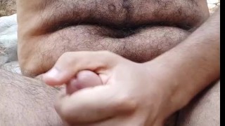 Hairy wild man jerking off outdoors with hit moanings and cum.