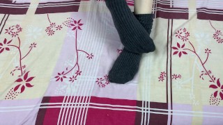 Girl in gray long socks on her legs caresses herself in bed