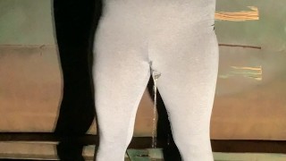 Girl pees in her yoga pants behind dumpster