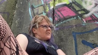 MILF fucks herself by busy mall