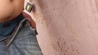 The guy jerks off his dick behind the garage and cums