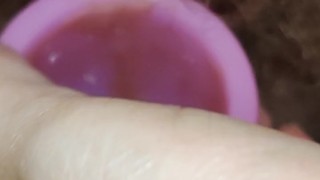 Hairy milf takes out a pink menstrual cup and pees on last day of period