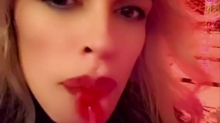 Hot blonde milf sexily sucks a lollipop in front of everyone in a cafe