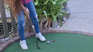 Small petite girl playing golf and not doing good at it